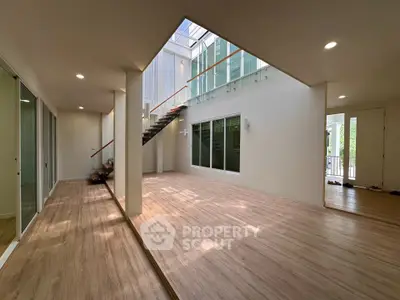 Spacious modern living room with wooden flooring and natural light
