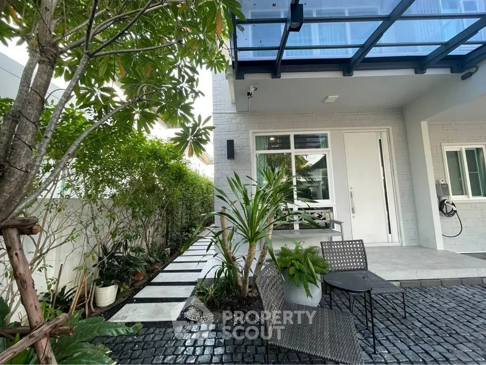 Modern home exterior with lush garden and stylish patio seating