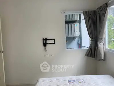 Bright bedroom with wall-mounted TV bracket and large window overlooking greenery.