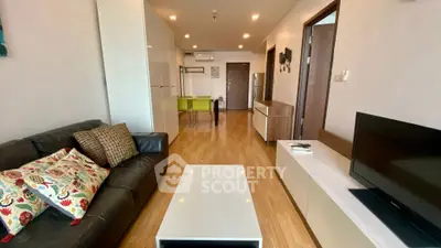 Modern living room with sleek furniture and open layout, featuring a cozy sofa and stylish decor.