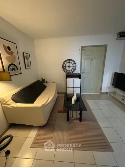 Cozy living room with modern decor, stylish sofa, and wall art, perfect for relaxation.