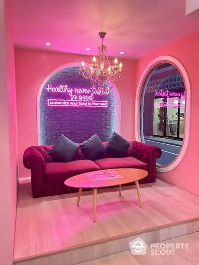 Chic pink-themed lounge with plush sofa and chandelier lighting