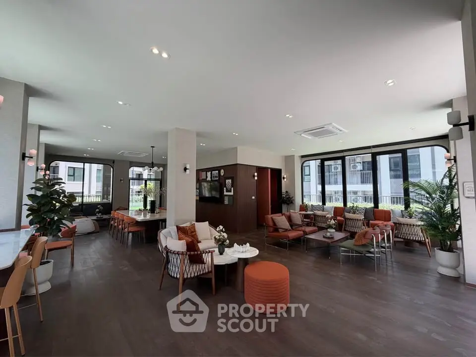 Spacious modern living room with elegant decor and large windows offering natural light.