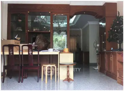 Spacious living room with elegant wooden furniture and decorative glass cabinets