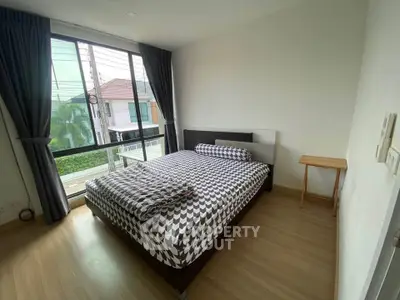 Spacious bedroom with large window and modern decor in a stylish home.