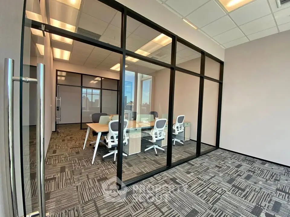 Modern office space with glass walls and stylish furniture, perfect for a professional work environment.