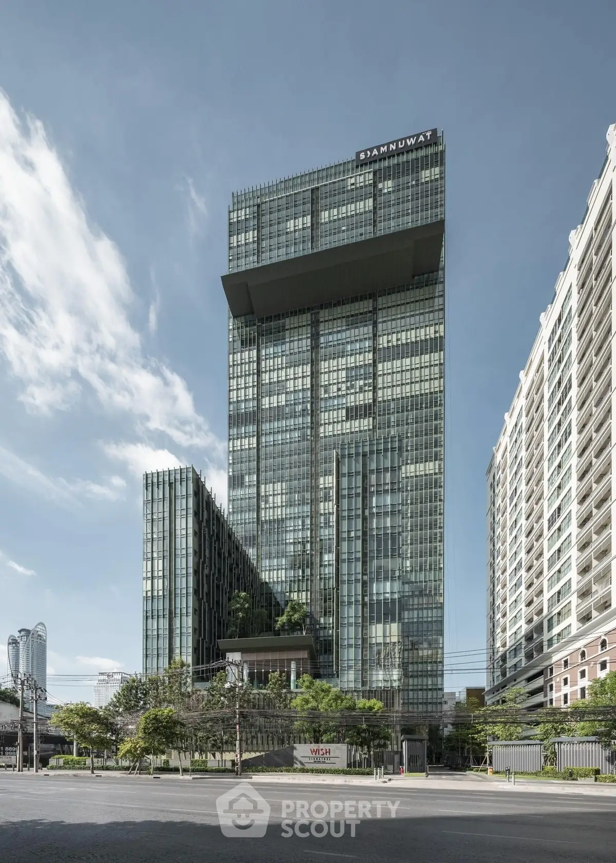 Stunning modern high-rise building with sleek glass facade and urban surroundings.