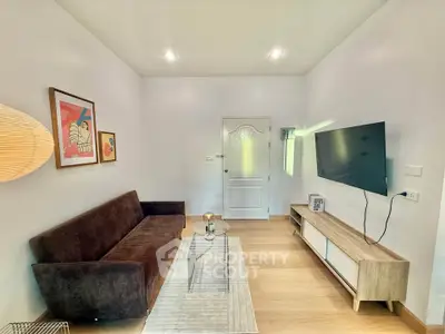 Modern living room with sleek furniture and wall-mounted TV, perfect for cozy relaxation.