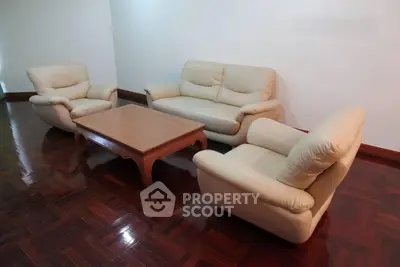 Spacious living room with elegant leather sofas and polished wooden floor