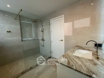 Luxurious modern bathroom with elegant marble finishes and spacious glass shower.