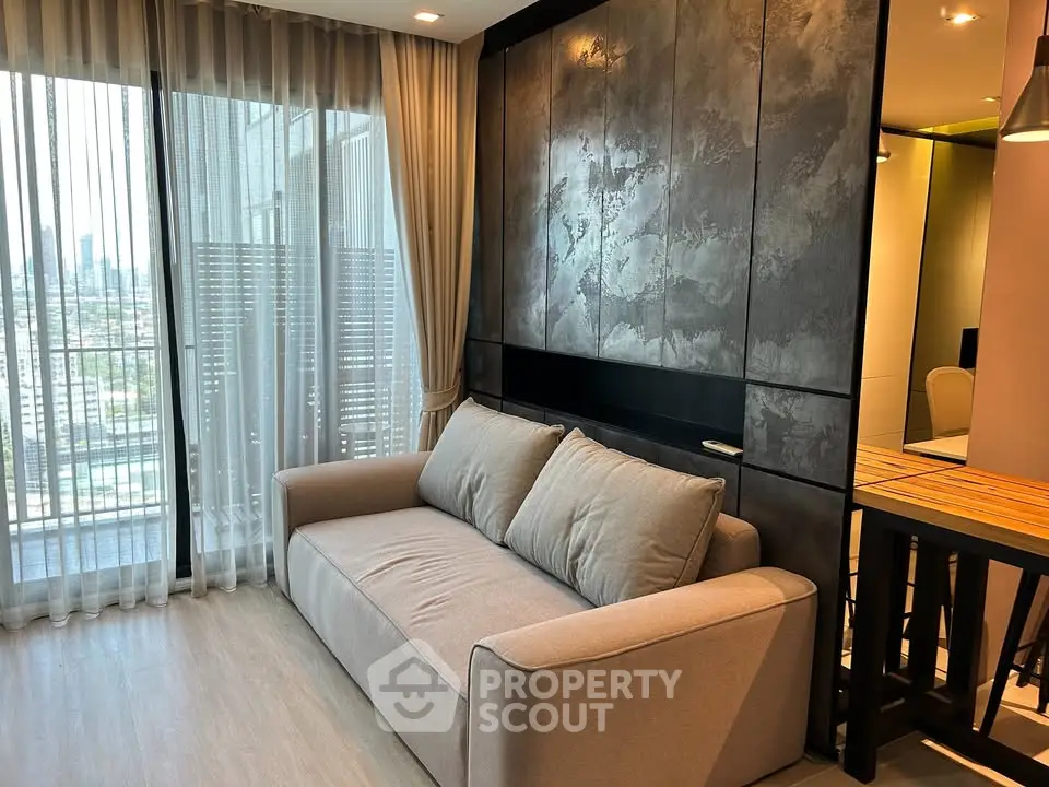 Modern living room with stylish sofa and city view through large windows.