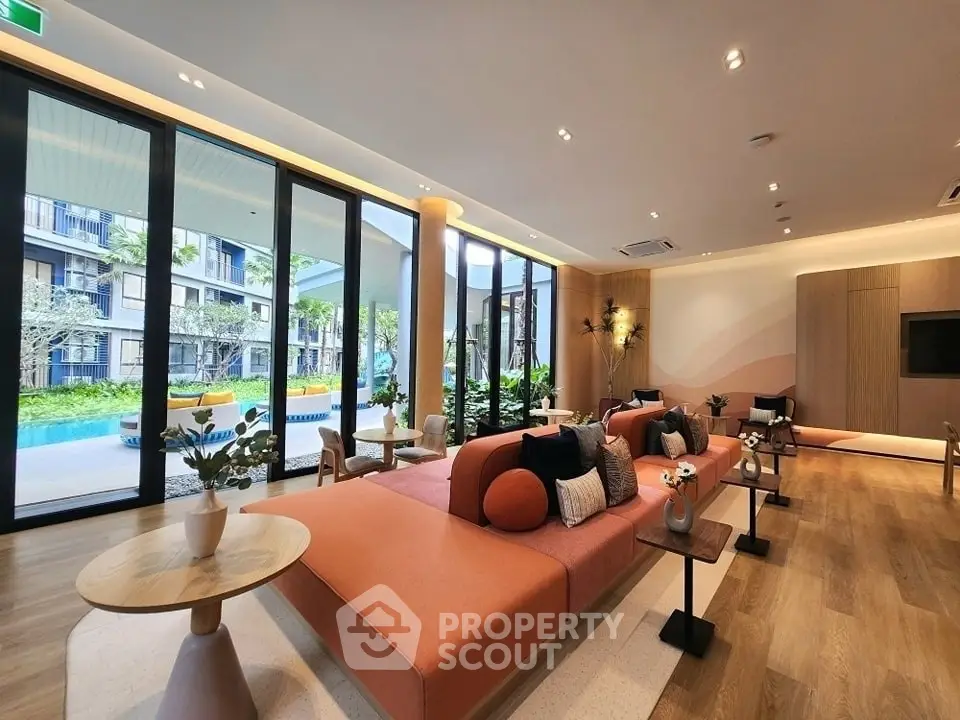 Luxurious modern living room with pool view, elegant decor, and ample natural light in a high-end apartment complex.