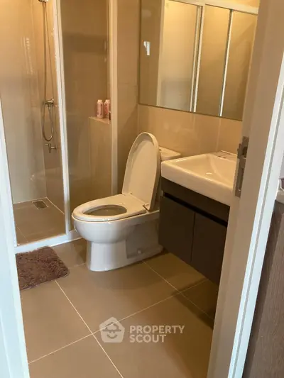 Modern bathroom with sleek fixtures and spacious shower in contemporary apartment.