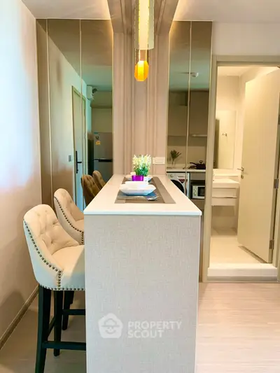 Modern kitchen with sleek bar counter and stylish chairs in a contemporary apartment.