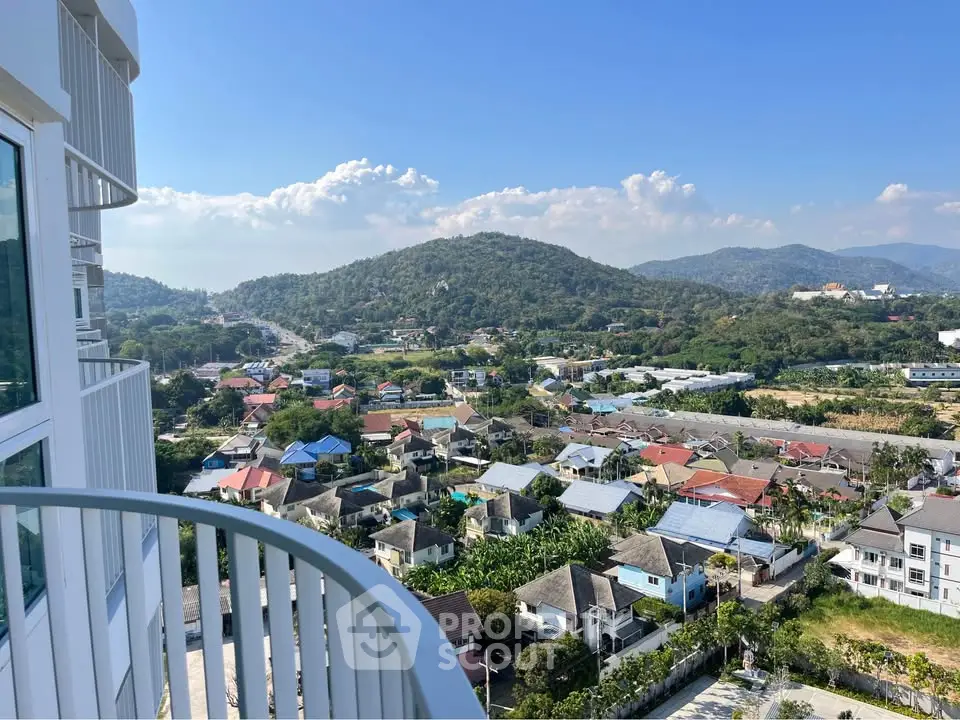 Stunning balcony view overlooking a scenic hillside and residential area.