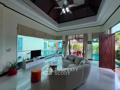 Luxurious living room with pool view, elegant furniture, and high ceiling in a modern villa.