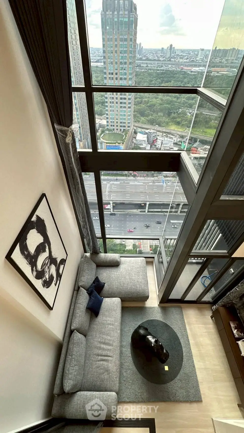 Stunning high-rise living room with floor-to-ceiling windows and breathtaking city view.