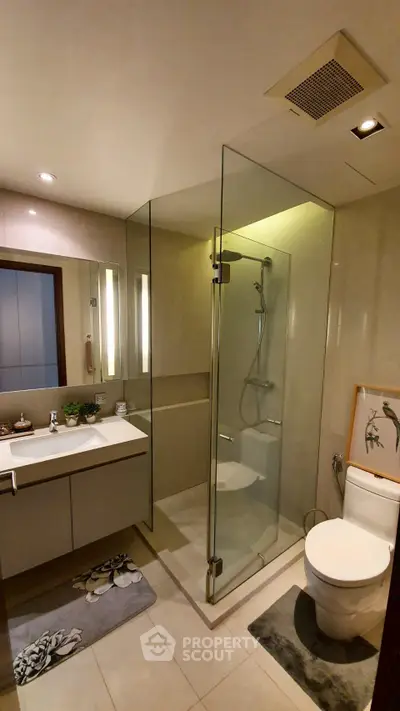 Modern bathroom with glass shower enclosure and sleek fixtures