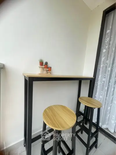 Modern balcony with stylish bar table and stools, perfect for relaxation.
