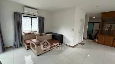 Spacious living room with modern furniture and large window for natural light.