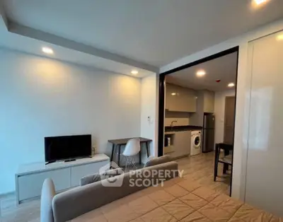 Modern studio apartment with open layout, featuring a cozy living area and a fully equipped kitchen.