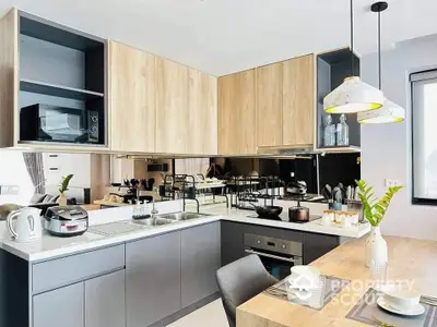 Modern kitchen with sleek design, featuring wooden cabinets and stylish lighting, perfect for culinary enthusiasts.