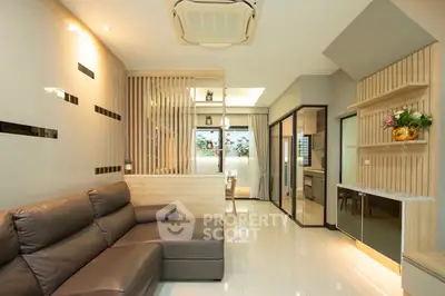 Modern living room with sleek design and open layout, featuring a comfortable leather sofa and stylish decor.