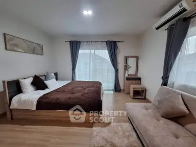 Spacious bedroom with modern decor and cozy seating area
