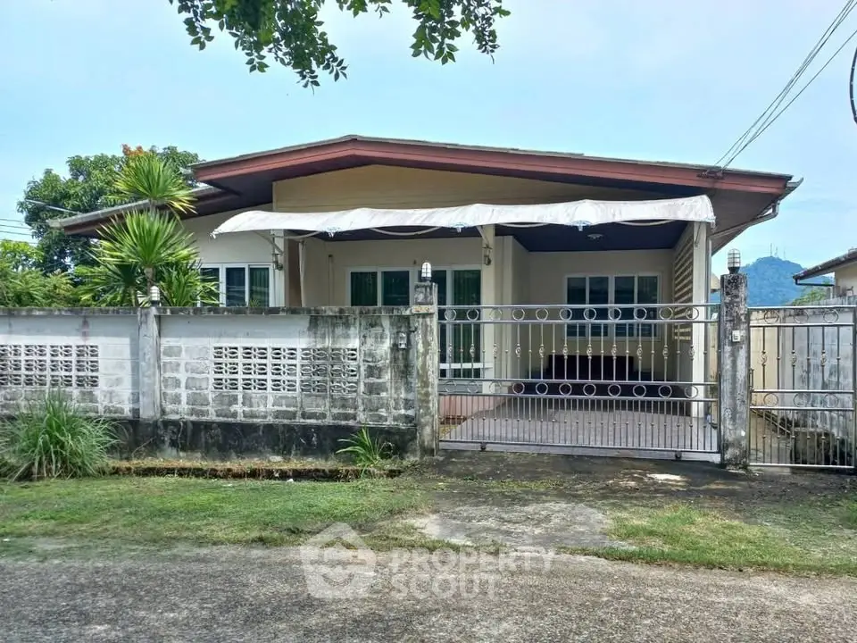 Charming single-story home with gated entrance and lush greenery, perfect for serene living.