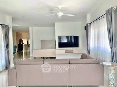 Spacious modern living room with sleek furniture and large windows.