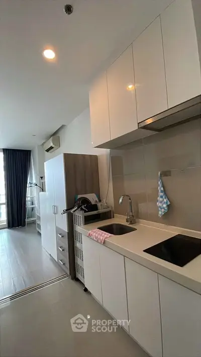Modern kitchen with sleek cabinetry and integrated appliances in a bright apartment.