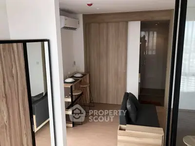 Modern compact living room with stylish wooden accents and cozy seating area.