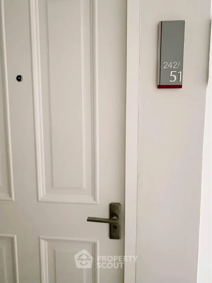 Modern apartment entrance with sleek door and room number signage