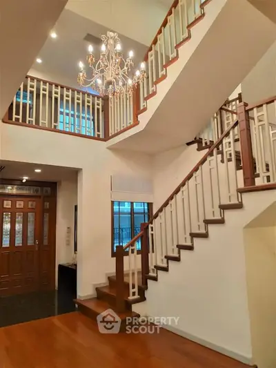 Elegant staircase with chandelier in a spacious home interior