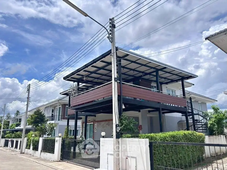 Modern two-story house with spacious balcony and sleek design in a suburban neighborhood.