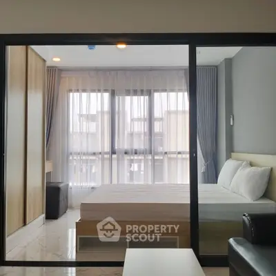 Modern bedroom with large windows and stylish decor in a contemporary apartment.