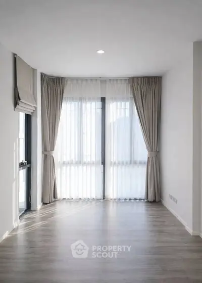 Bright empty room with large windows and elegant curtains, perfect for customization.