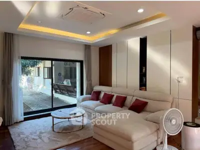 Spacious living room with modern decor and large sliding glass doors leading to a patio.