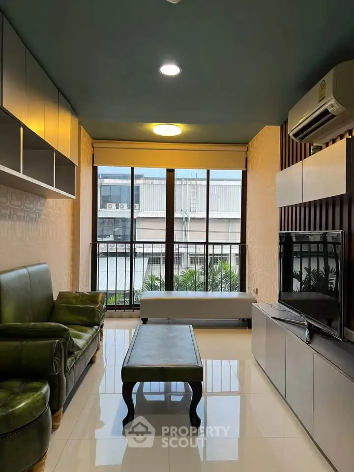 Modern living room with green leather sofa and large window view