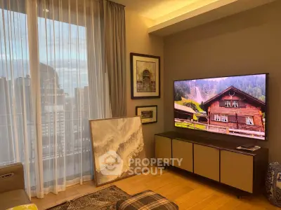 Stylish living room with large TV and city view through sheer curtains