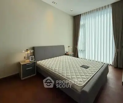 Spacious bedroom with modern decor and large window for natural light