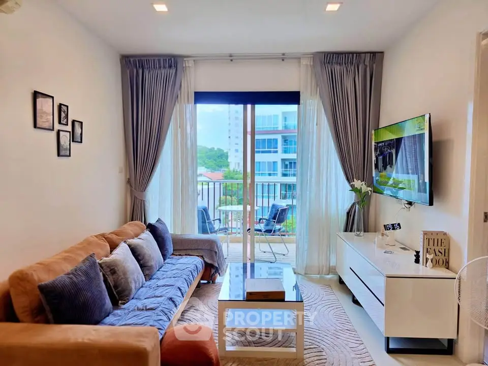 Stylish living room with modern decor and balcony view in a high-rise apartment.