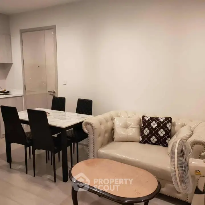 Modern living room with elegant sofa and dining area in open layout apartment.