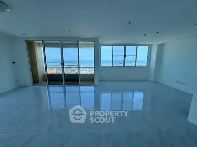 Spacious living room with large windows and stunning sea view, perfect for modern living.