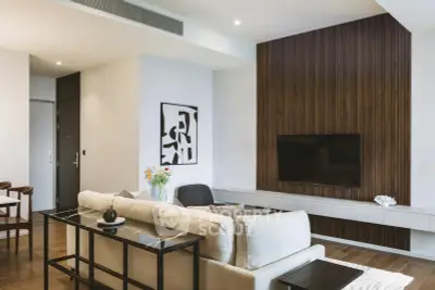 Modern living room with stylish decor and wall-mounted TV, featuring elegant wood paneling and contemporary furniture.