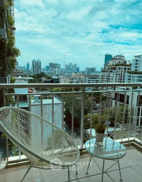 Stunning city view from a modern balcony with stylish outdoor seating.
