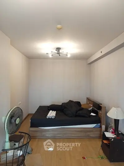 Cozy bedroom with modern lighting and wooden flooring, featuring a comfortable bed and stylish decor.