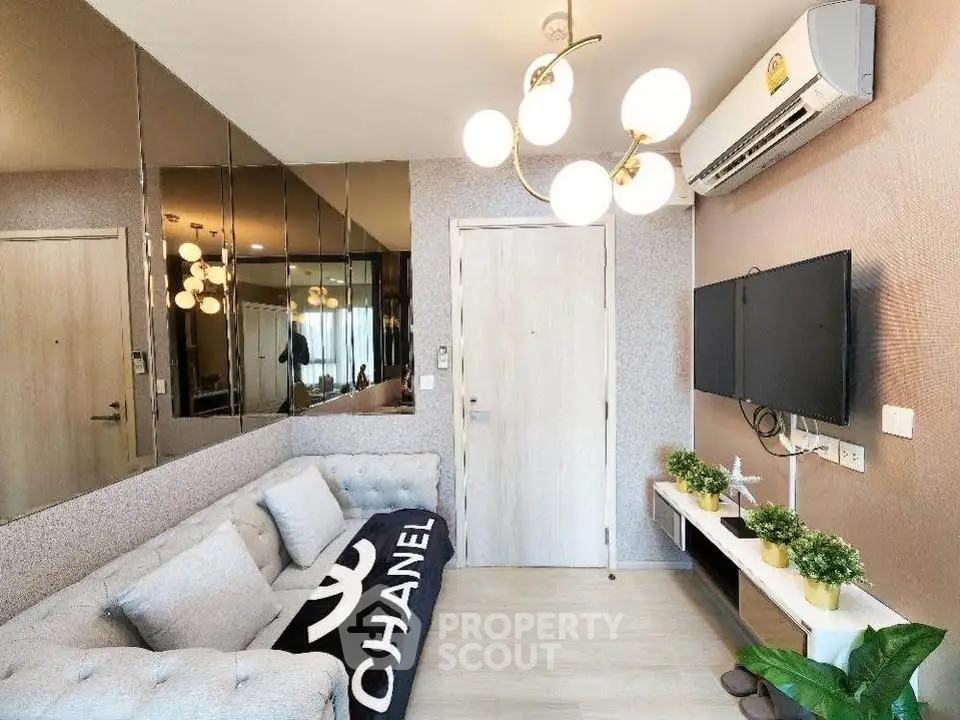 Modern living room with stylish decor, mirrored wall, and cozy seating in a chic apartment.