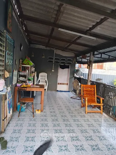 Charming covered balcony with seating and tiled floor, perfect for relaxation.