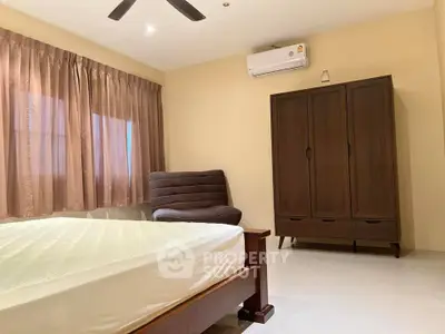 Spacious bedroom with modern furniture and air conditioning, perfect for comfort and relaxation.